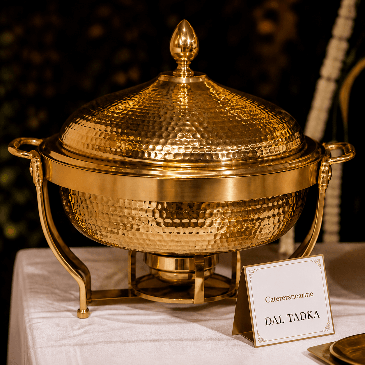 Close-up of a single hammered gold chafing dish with a menu card